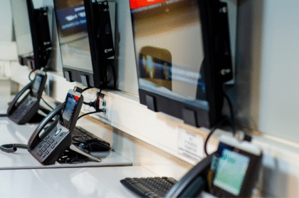 A picture of telephones and desktops on a table.